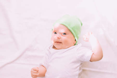 The baby is lying in his crib and looking at the camera. A happy child. children's article. copy...