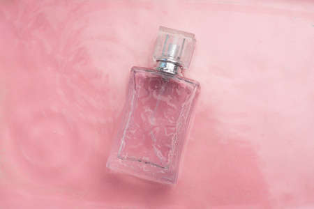 Perfume bottle on the background and water drops. A bottle of perfume without inscriptions. Smell....