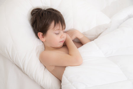 The child is sleeping sweetly in his bed . Sweet babys dream. The child is in bed . An article about childrens dreams. Boyの写真素材
