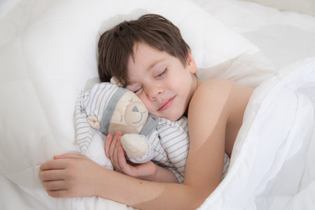 The child is sleeping sweetly in his bed . Sweet babys dream. The child is in bed . An article about childrens dreams. Boyの写真素材
