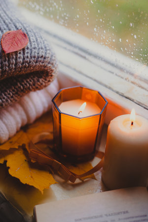 A burning candle on the window is autumn . the comfort of home . autumn comfort . autumn mood. The chondra .の写真素材