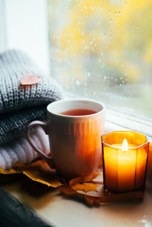 A burning candle on the window is autumn . the comfort of home . autumn comfort . autumn mood. The chondra .の写真素材