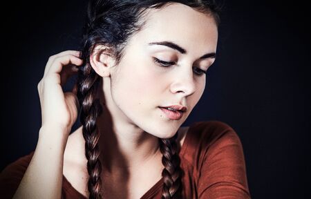 girl with braids looking downhill down on black backgroundの写真素材