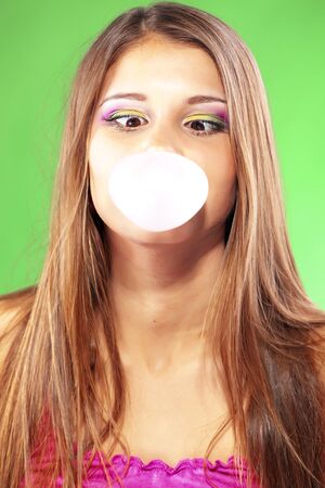 Girl blowing a big bubble gum bubbleの写真素材