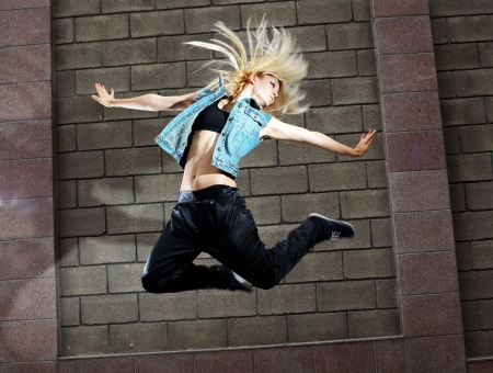 Teenage girl dancing hip-hop over the street wall Teenage girl dancing hip-hop over the street wall