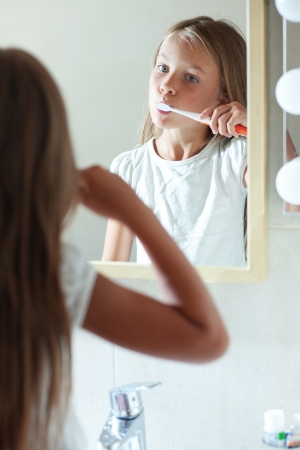 Little girl brushes teeth in the bathroomの写真素材