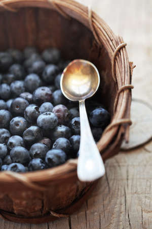 Ripe blueberries in basket on a wooden tableの写真素材