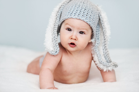 Portrait of a cute 6 months baby wearing rabbit hatの写真素材