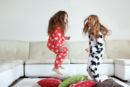 Children in soft warm pajamas playing at homeの写真素材