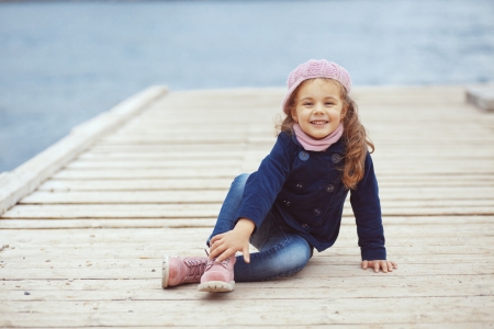 Portrait of 4 years old girl walking on berth near sea in the city, still life photoの写真素材