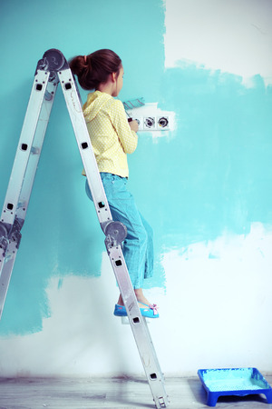 7 years old girl painting the wall at home, style toningの写真素材