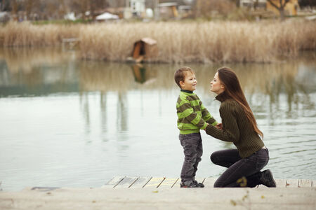Young mother walking with her little son outdoors in autumnの写真素材