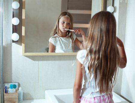 Little girl brushes teeth in the bathroomの写真素材