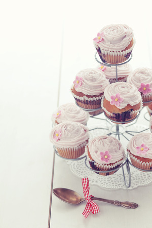 Pink cupcakes on cupcake stand on wooden backgroundの写真素材