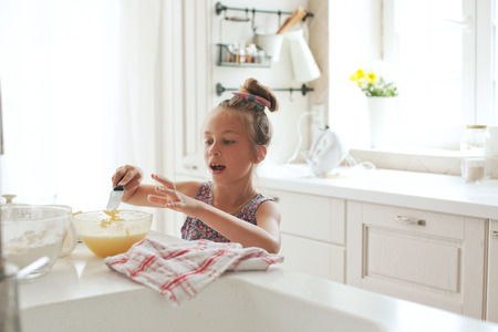 7 years old school girl cooking at the kitchen, casual lifestyle photo series