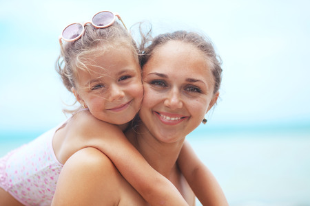 Happy family resting at beach in summer, mother with her 5 years old childの写真素材