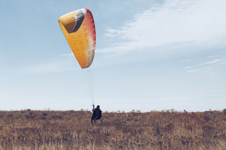 Paraglider taking off from a hillの写真素材