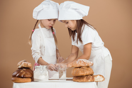 5 years old girls cooking together, studio shot