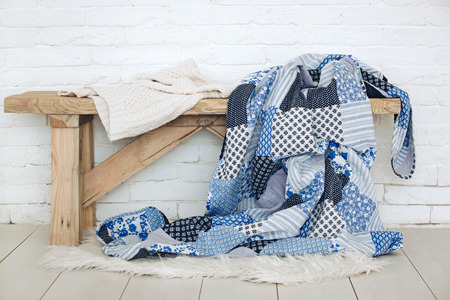 Wooden rustic bench with warm cozy bedding on it