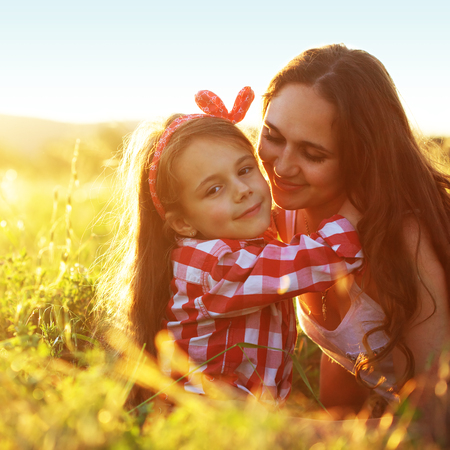 Mom and her 6 years old child playing in spring fieldの写真素材