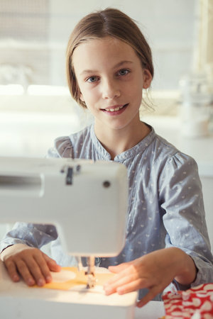 9 years old child studying work with sewing machineの写真素材