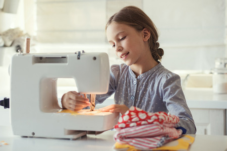 9 years old child studying work with sewing machineの写真素材