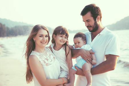 Family walking on the evening beach during sunset. Childen with parents.の写真素材