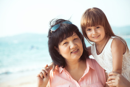 Grandmother and granddaughter standing in over sea