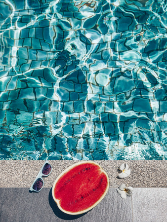 Watermelon, sunglasses and spa flowers near the blue pool. Tropical fruit diet. Summer holiday idyllic.の写真素材