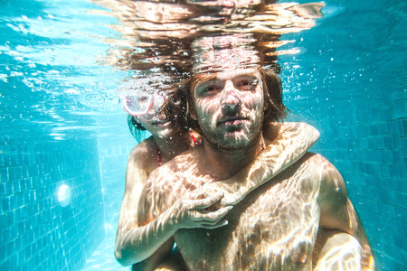 9 years old child with her dad swimming in the pool, underwater shotの写真素材