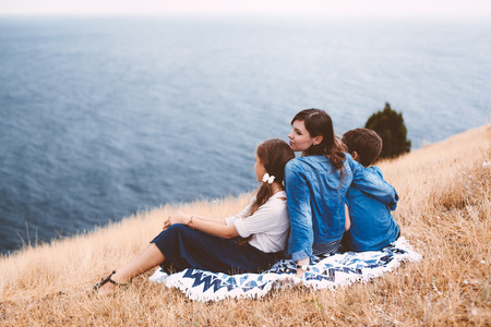 Mom with two preteen children walking outdoor, cool autumn weatherの写真素材