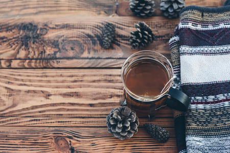 Mug with tea bag and sweater on old brown wooden table, top viewの写真素材