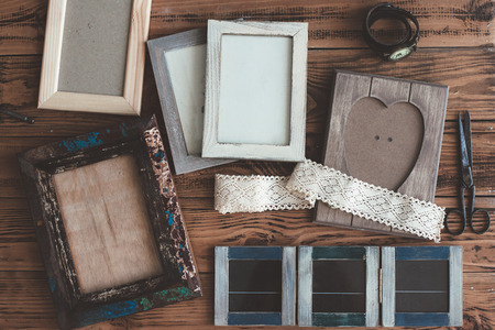 Many wooden photo frames on the rustic table, top viewの写真素材
