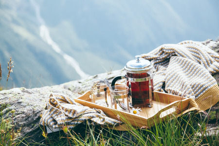 Tea on wooden tray over mountains view. Outdoor breakfast in hike.の写真素材