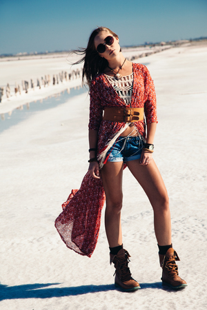 Fashion model wearing bohemian chic clothing posing on the salt beach outdoor.の写真素材