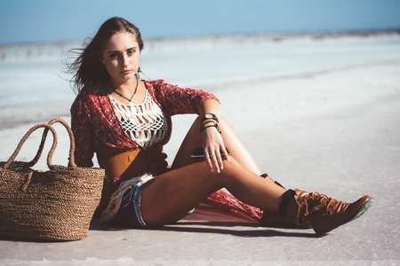 Fashion model wearing bohemian chic clothing posing on the salt beach outdoor.の写真素材