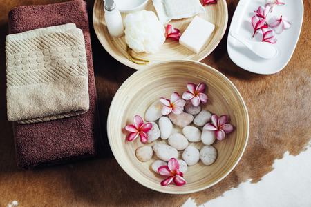 Foot bath in bowl with lime and tropical flowers, organic spa pedicure treatment, top view.の写真素材