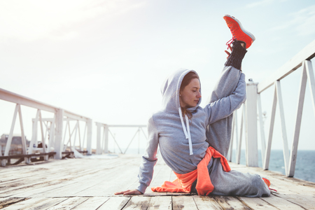 Fitness sport girl in fashion sportswear doing yoga fitness exercise in the street. Outdoor workout, urban style.の写真素材