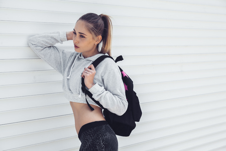 Fitness sporty girl wearing fashion sportswear over street wall, outdoor sports, urban style. Teen model in swag clothes posing outside.の写真素材
