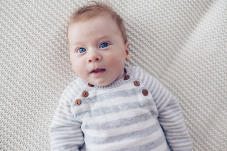Portrait of a cute 2 month old baby lying down on a crochet blanket
