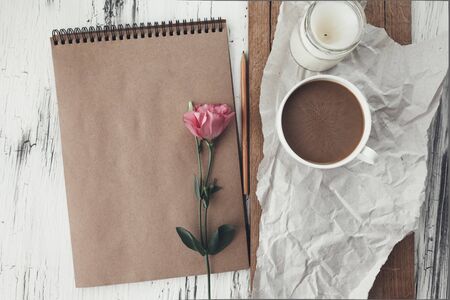 Wooden tray with coffee and spring flowers, craft paper and sketchbook. Eco home objects concept.の写真素材