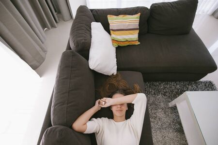 Teen girl relaxing on couch in hotel room, top viewの写真素材