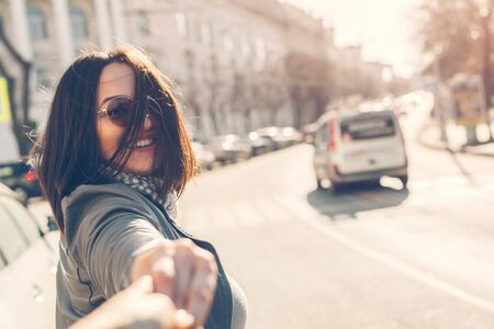 Portrait of happy and carefree plus size woman walking down city street in sunny weather, having good mood and smiling. Follow me travel concept.の写真素材