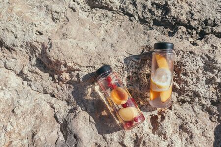 Fruit water with berries in plastic reusable My bottle on the beach take away. Detox drink for healthy summer lifestyle.の写真素材