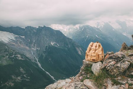 Canvas backpack on mountain over beautiful alpine view. Spring travel concept scene.の写真素材