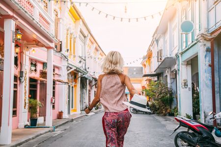Boho girl walking on the city street. Travelling in Phuket Old Town in Thailand.の写真素材