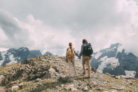 Father with child standing on the top of the mountain, winter hike with backpacks, alpine viewの写真素材