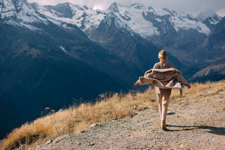 Woman walking in mountains enjoying beautiful landscape and feeling freedom and happiness. Autumn...
