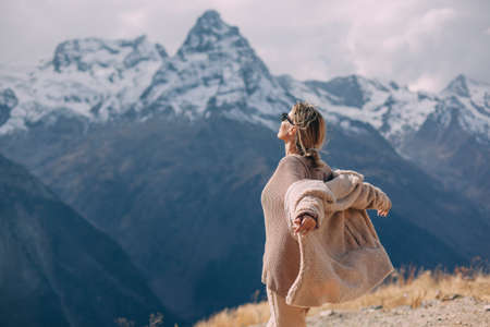 Woman walking in mountains enjoying beautiful landscape and feeling freedom and happiness. Autumn trip to nordic countries.の写真素材