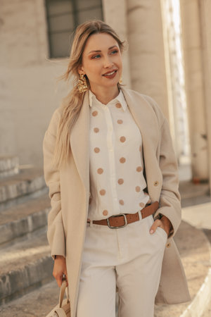 Fashion woman wearing beige trendy coat walking on the streetの写真素材